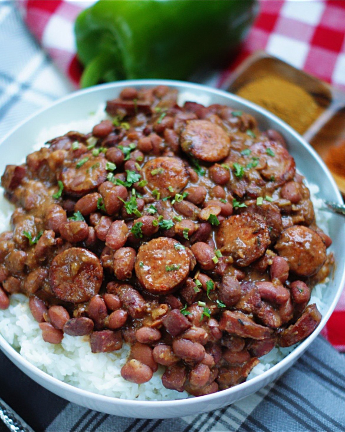 Bowl of creamy red beans with sliced beef sausage served over white rice